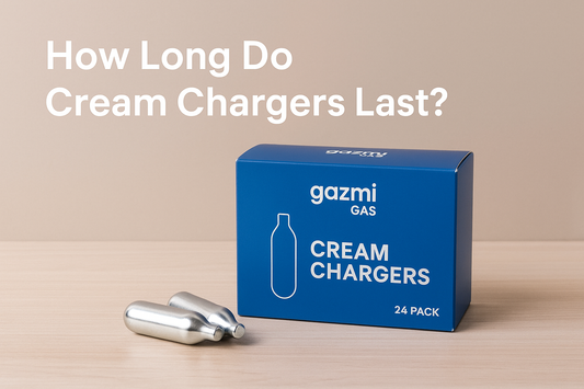 Gazmi Gas cream chargers box with two chargers on a wooden table, beige background, text reads “How Long Do Cream Chargers Last?”.